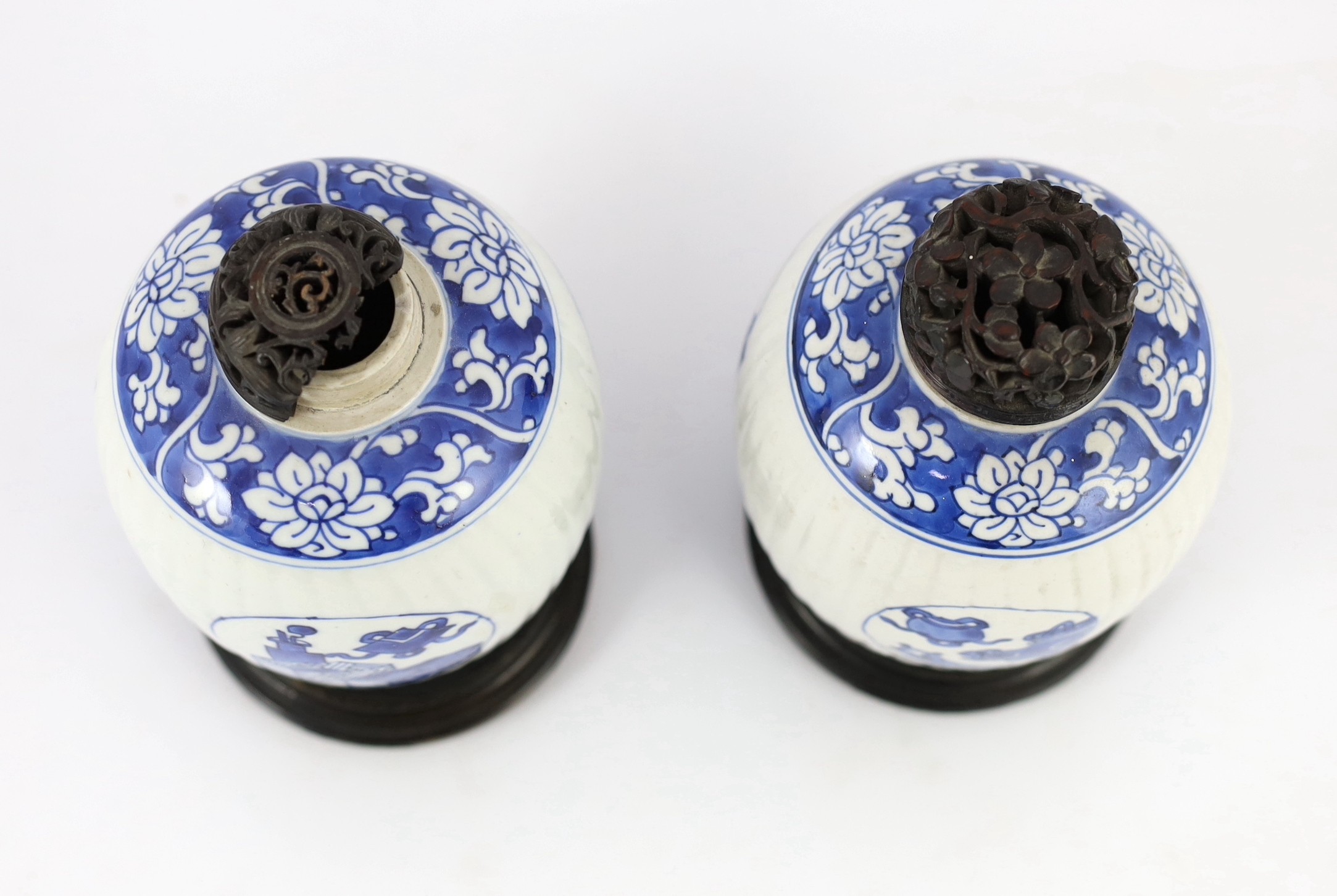 A pair of Chinese blue and white ribbed ovoid jars, Kangxi period, 13.4cm high, excluding wood stand and cover, one chipped with hairline crack